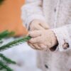 Close-up of a Child Wearing Gloves Touching a Christmas Tree