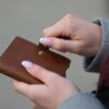 person holding brown leather wallet