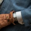 person wearing blue leather gloves with watch