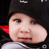 a baby wearing a black hat and scarf